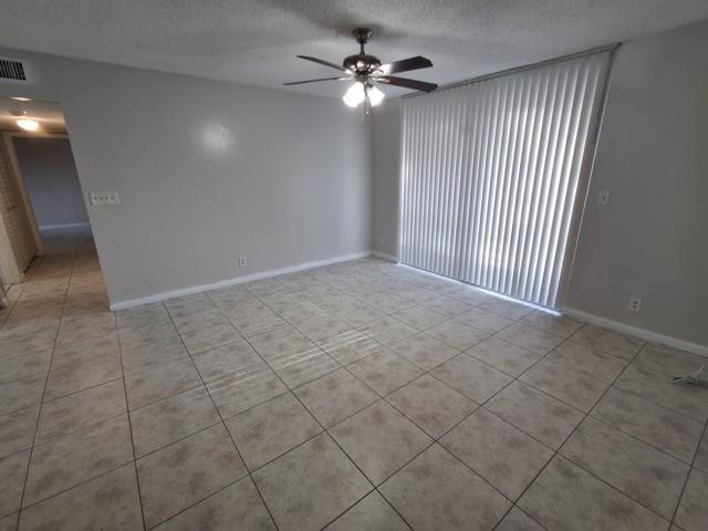 741 Lyons Road, Unit 17106 Coconut Creek, FL 33063 - Photo 3 of 28 an empty room with windows and fan