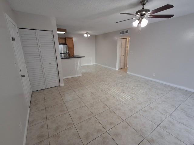 741 Lyons Road, Unit 17106 Coconut Creek, FL 33063 - Photo 4 of 28 an empty room with windows and fan