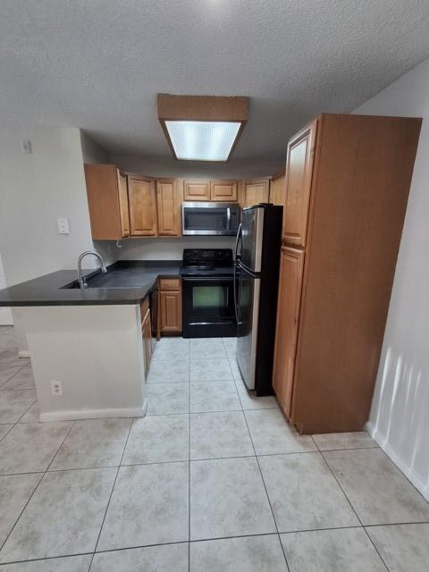 741 Lyons Road, Unit 17106 Coconut Creek, FL 33063 - Photo 6 of 28 a kitchen with stainless steel appliances a refrigerator and a stove