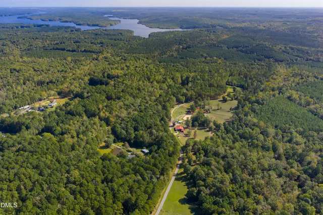 an aerial view of residential house with outdoor space and trees all around