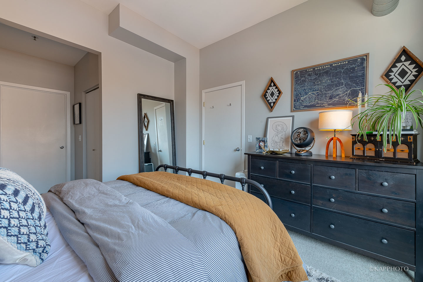 910 West Madison Street, Unit 906E Chicago, IL 60607 - Photo 20 of 26 a bedroom with a bed and a mirror on dresser