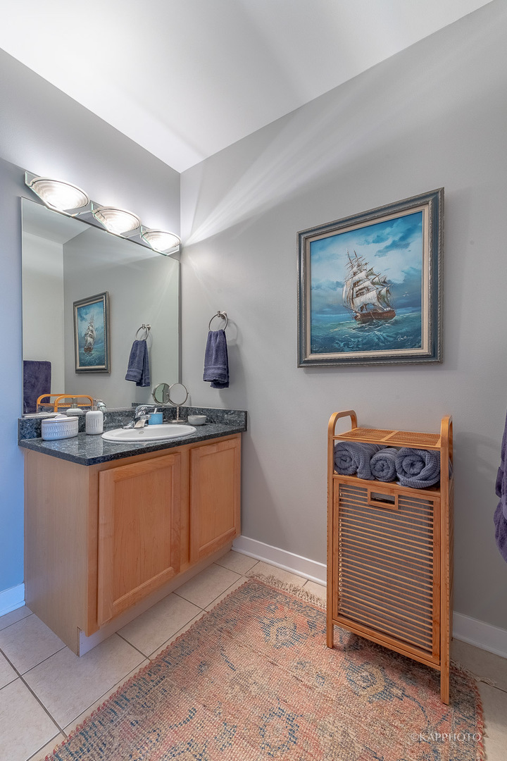 910 West Madison Street, Unit 906E Chicago, IL 60607 - Photo 23 of 26 a bathroom with a sink a mirror and a vanity