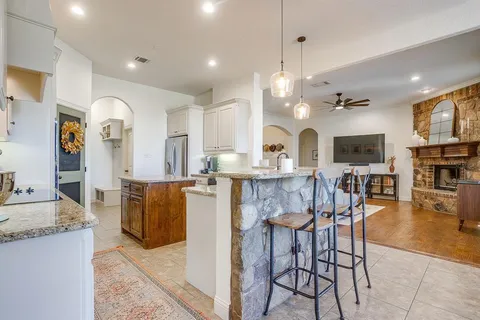 a kitchen with stainless steel appliances granite countertop a stove top oven a sink dishwasher and microwave with wooden floor