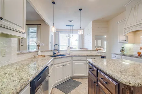a large kitchen with granite countertop a refrigerator and a sink