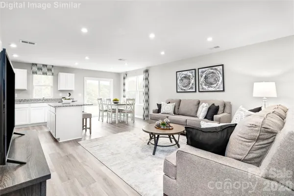a living room with furniture and view of kitchen