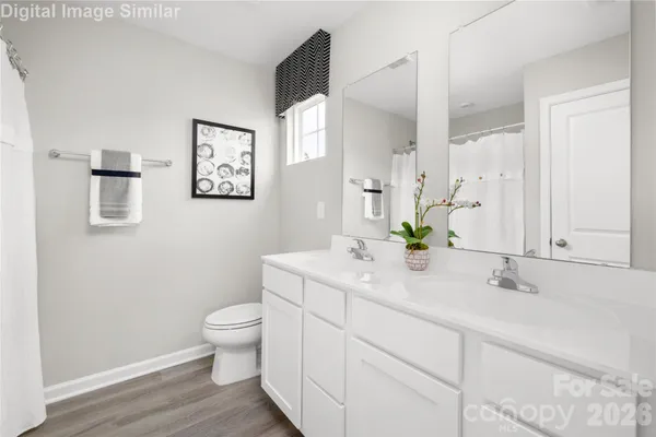 a bathroom with a granite countertop sink a toilet and a mirror