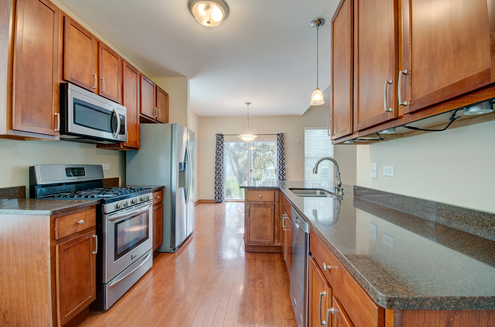 520 Frieh Drive Romeoville, IL 60446 - Photo 9 of 26 a kitchen with stainless steel appliances granite countertop a stove a sink and a microwave
