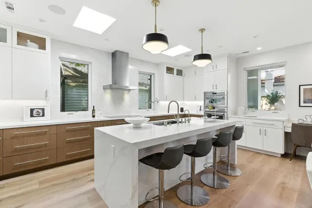 a kitchen with a stove a sink a dining table and chairs