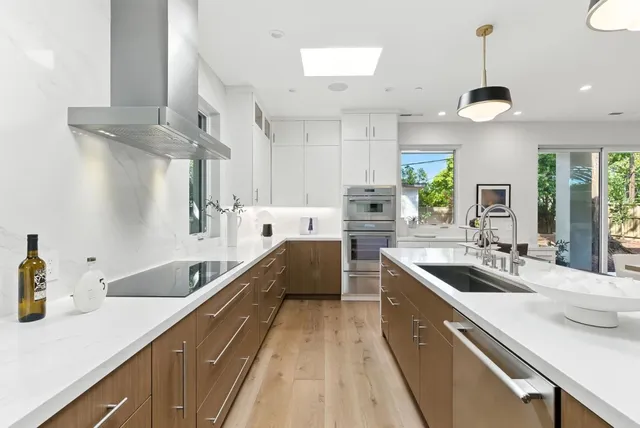 a kitchen with stainless steel appliances a sink stove and cabinets