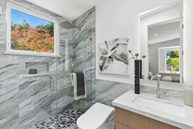 a bathroom with a sink a toilet and mirror