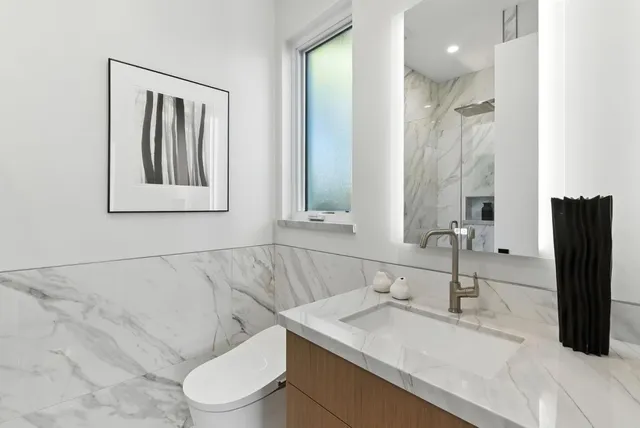 a bathroom with a toilet sink and mirror
