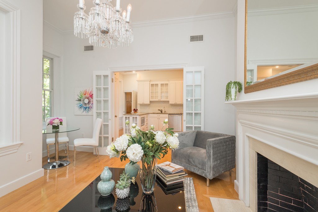5 Chestnut Street, Unit 1 Boston, MA 02108 - Photo 3 of 14 a living room with furniture a chandelier and a fireplace