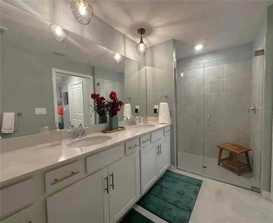 a bathroom with a double vanity sink mirror and shower