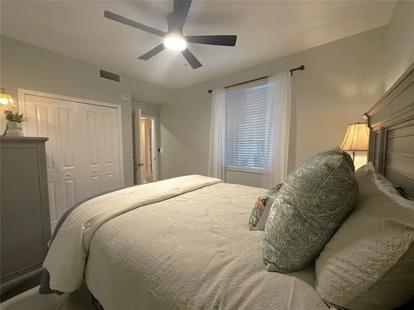 a spacious bedroom with a bed and a chandelier