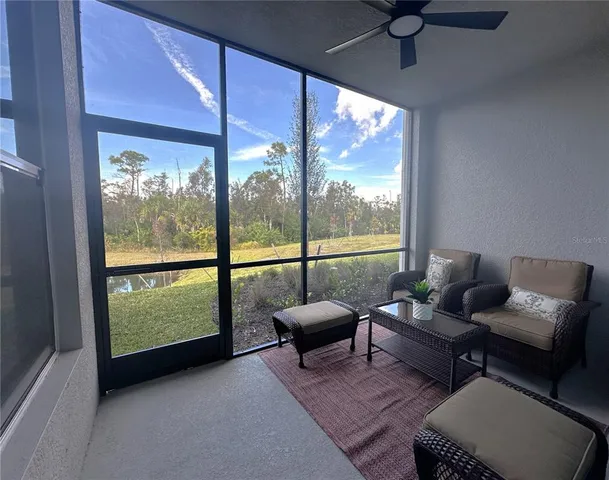 a living room with furniture and a floor to ceiling window