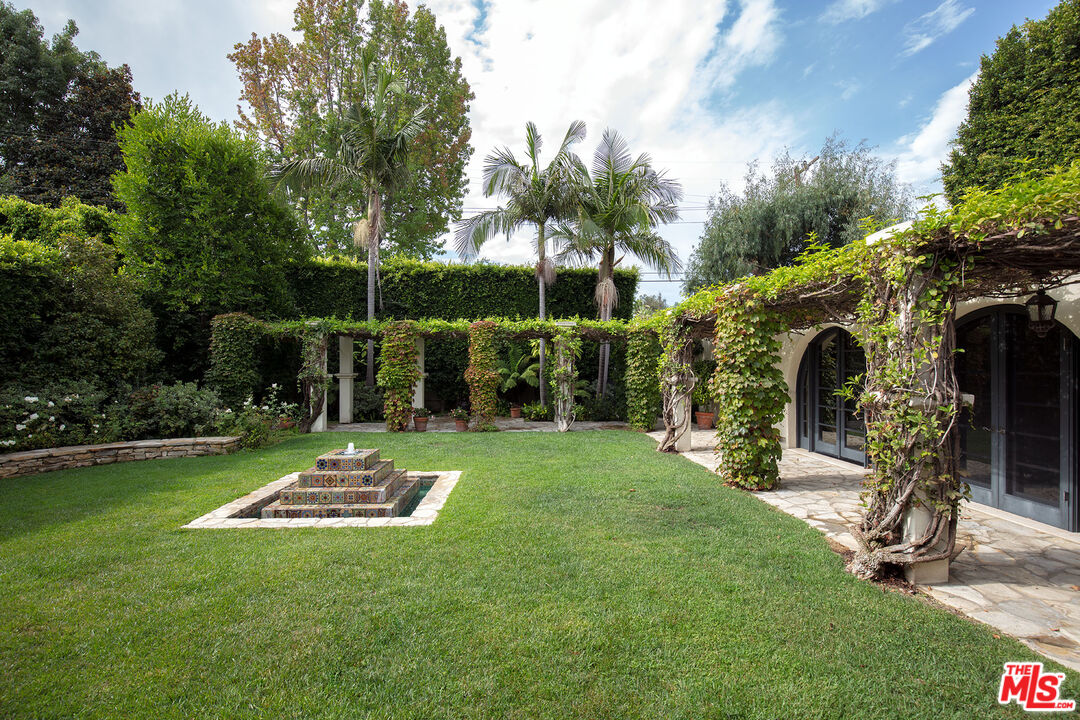 703 Walden Drive Beverly Hills, CA 90210 - Photo 11 of 22 a view of backyard with table and chairs and potted plants