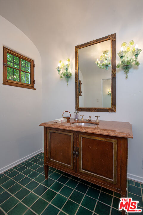 703 Walden Drive Beverly Hills, CA 90210 - Photo 20 of 22 a bathroom with a sink and a mirror