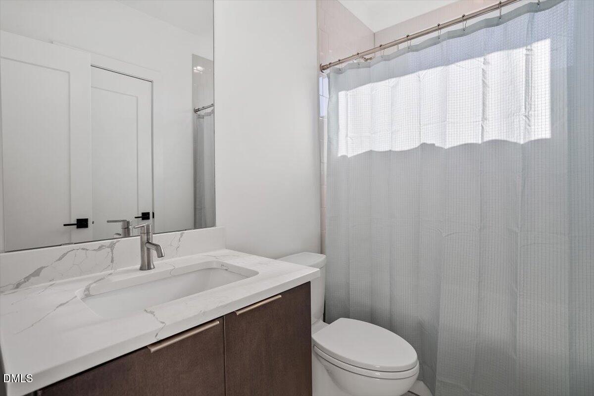 603 North Queen Street Durham, NC 27701 - Photo 33 of 40 a bathroom with a sink a toilet and shower curtain