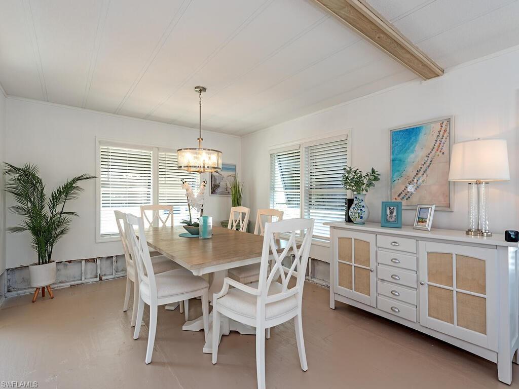 777 Walkerbilt Road, Unit 17 Naples, FL 34110 - Photo 3 of 19 a dining room with furniture a chandelier and window