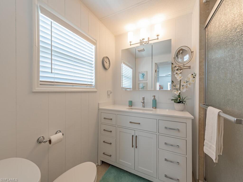 777 Walkerbilt Road, Unit 17 Naples, FL 34110 - Photo 7 of 19 a bathroom with a toilet a sink and mirror