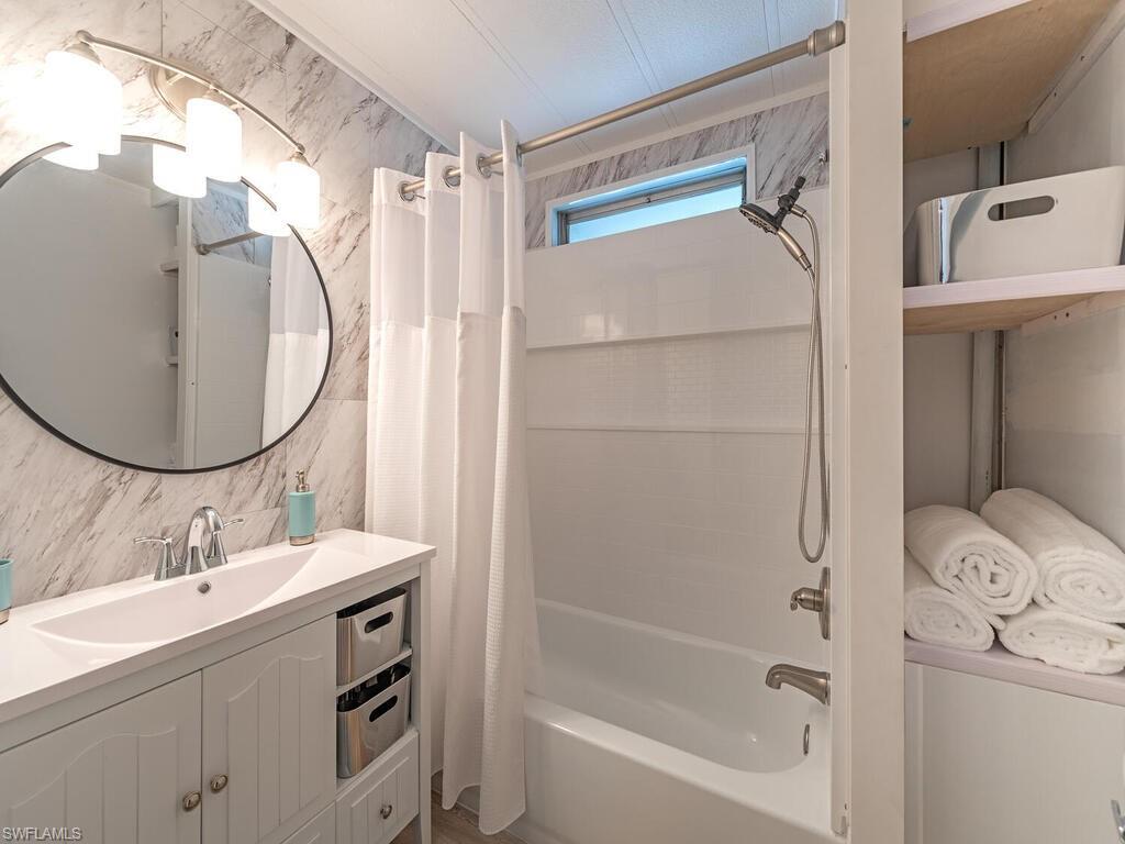 777 Walkerbilt Road, Unit 17 Naples, FL 34110 - Photo 9 of 19 a bathroom with a sink mirror toilet and bathtub