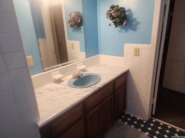 a bathroom with a sink vanity and a mirror