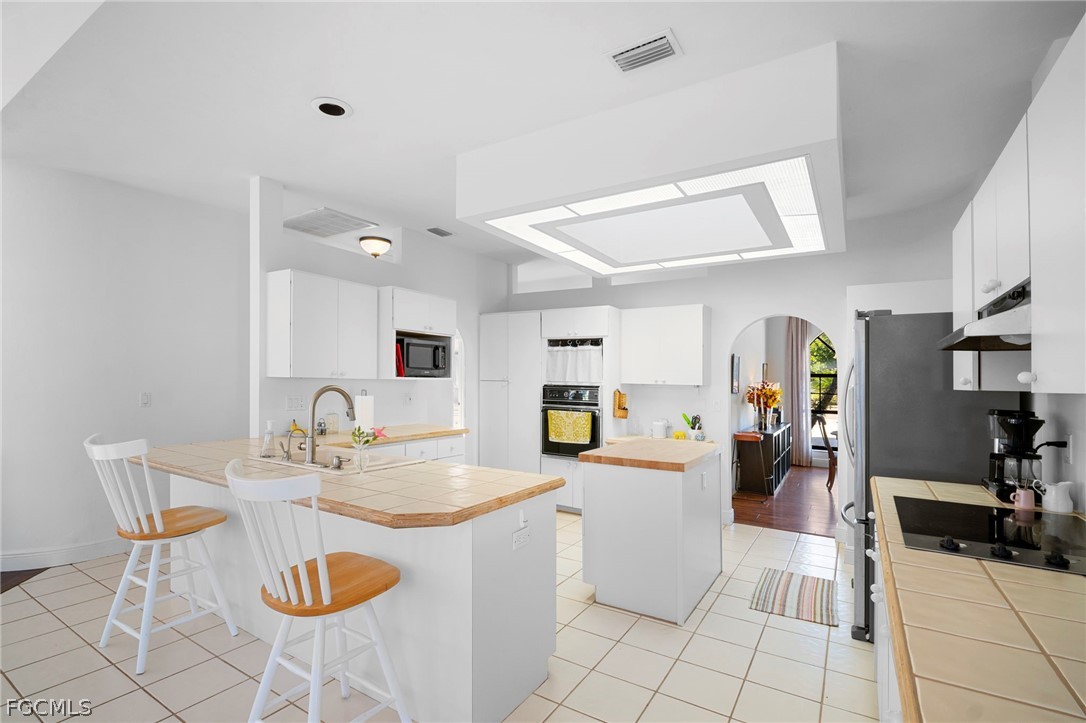 11772 Mahogany Run Fort Myers, FL 33913 - Photo 20 of 50 a kitchen with a sink dining table and chairs
