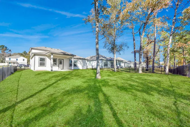 a view of a white house with a big yard and large trees