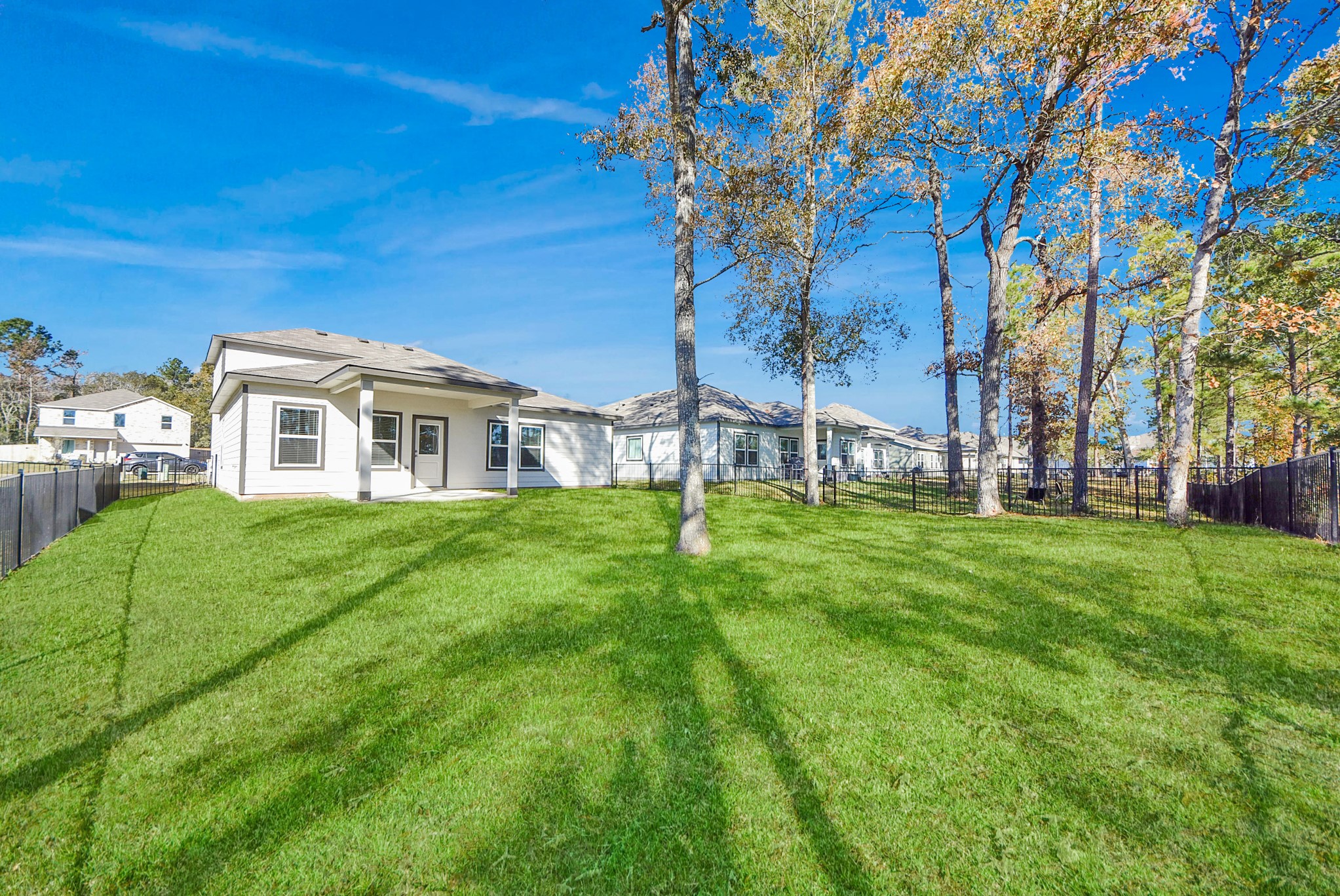 473 Shoreview Drive Conroe, TX 77303 - Photo 11 of 49 a view of a white house with a big yard and large trees
