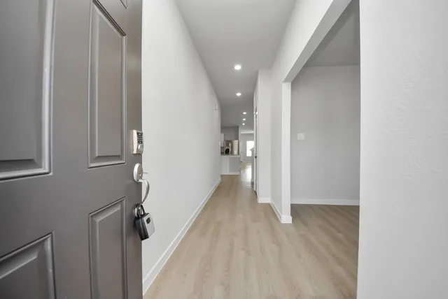 a view of a hallway with wooden floor and staircase