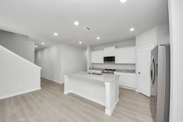 a kitchen with stainless steel appliances a refrigerator and a stove top oven