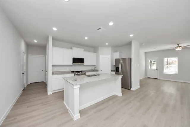 a view of kitchen with stainless steel appliances refrigerator stove microwave and cabinets
