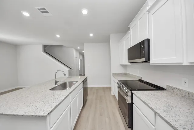 a kitchen with a sink stove and microwave