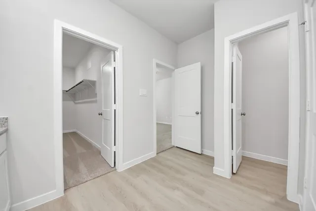 an empty room with wooden floor and mirror
