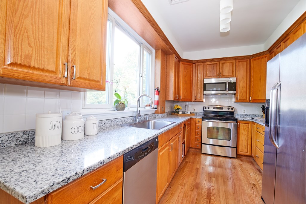 92 Coolidge Street, Unit 2 Brookline, MA 02446 - Photo 7 of 29 a kitchen with stainless steel appliances granite countertop a sink a stove and a refrigerator