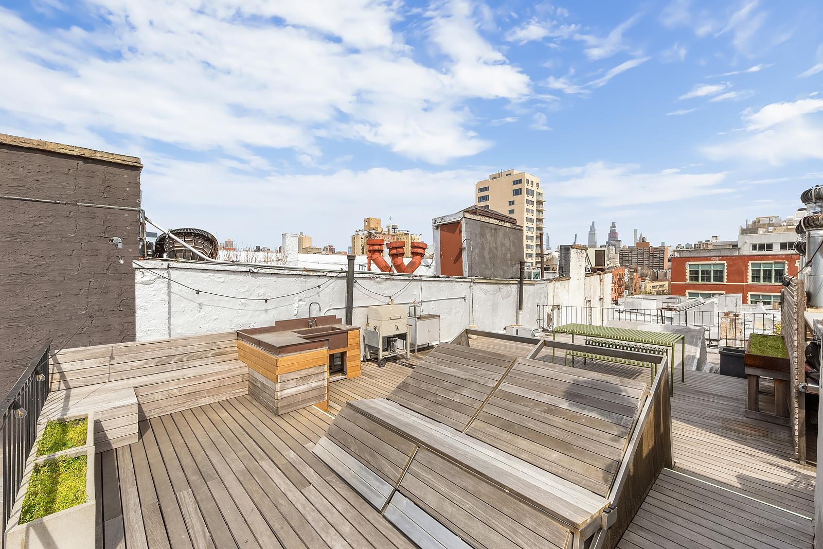 a view of a rooftop deck with chairs and city view