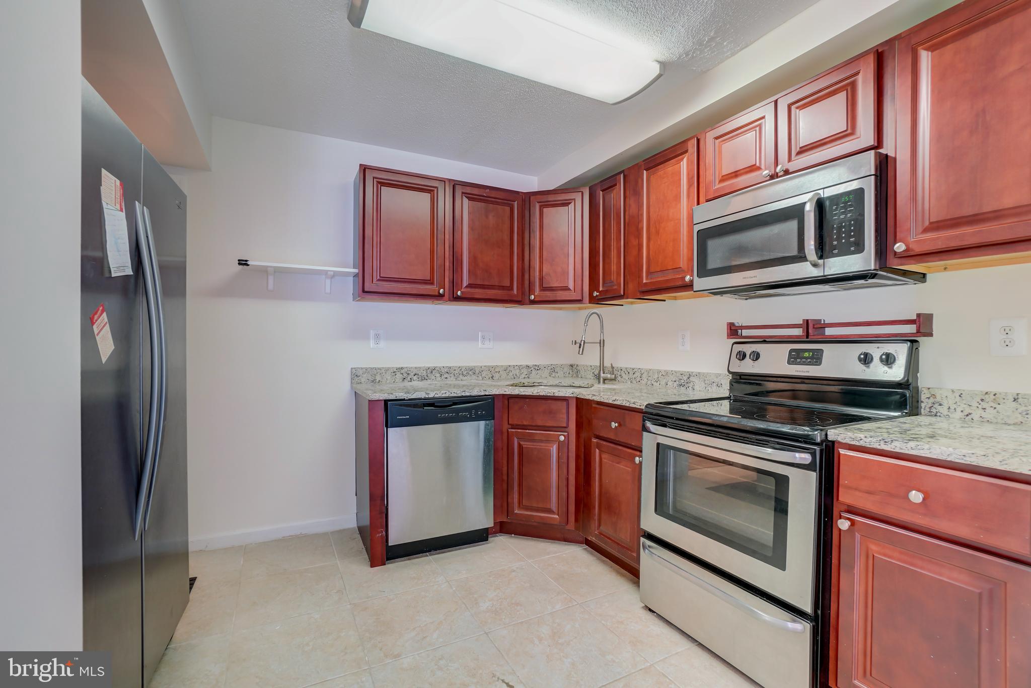 628 Four Mile Road Alexandria, VA 22305 - Photo 8 of 29 a kitchen with stainless steel appliances granite countertop a stove microwave and refrigerator