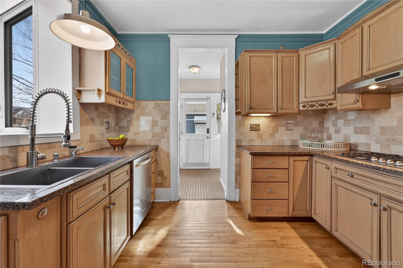 3056 York Street Denver, CO 80205 - Photo 11 of 44 a kitchen with kitchen island granite countertop a sink and cabinets