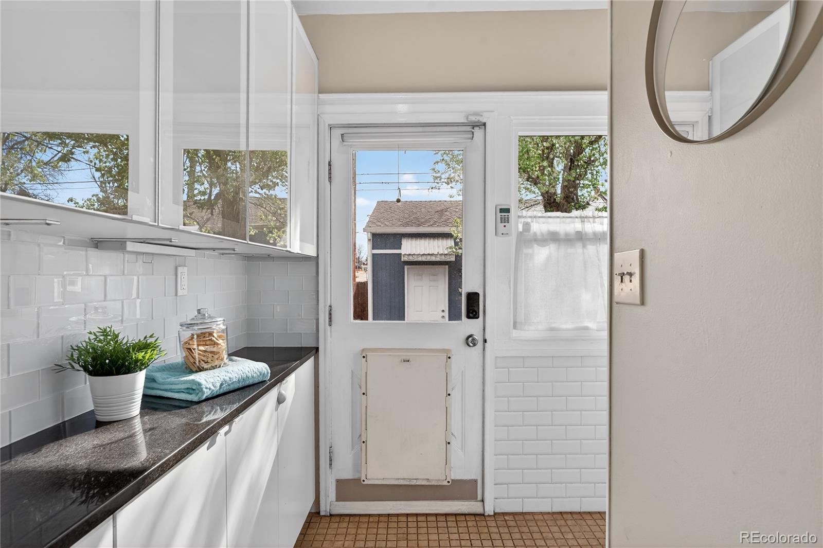 3056 York Street Denver, CO 80205 - Photo 15 of 44 a kitchen with a white cabinets and a potted plant