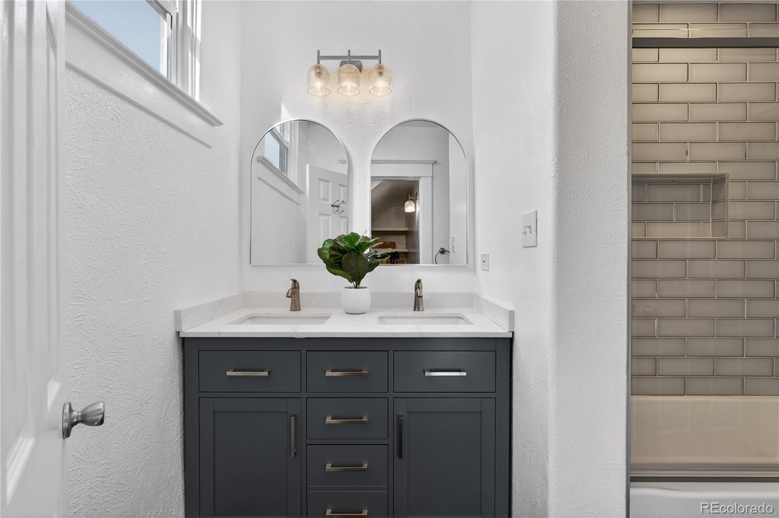 3056 York Street Denver, CO 80205 - Photo 22 of 44 a bathroom with a double vanity sink and a mirror