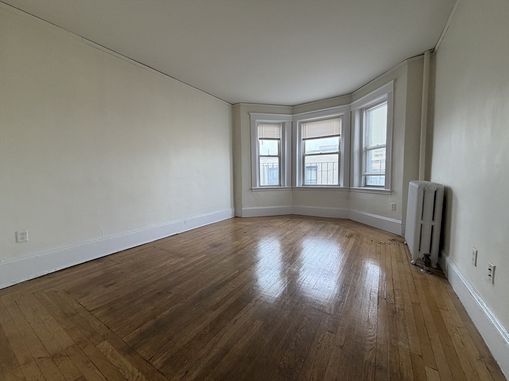 a view of wooden floor and windows in an empty room