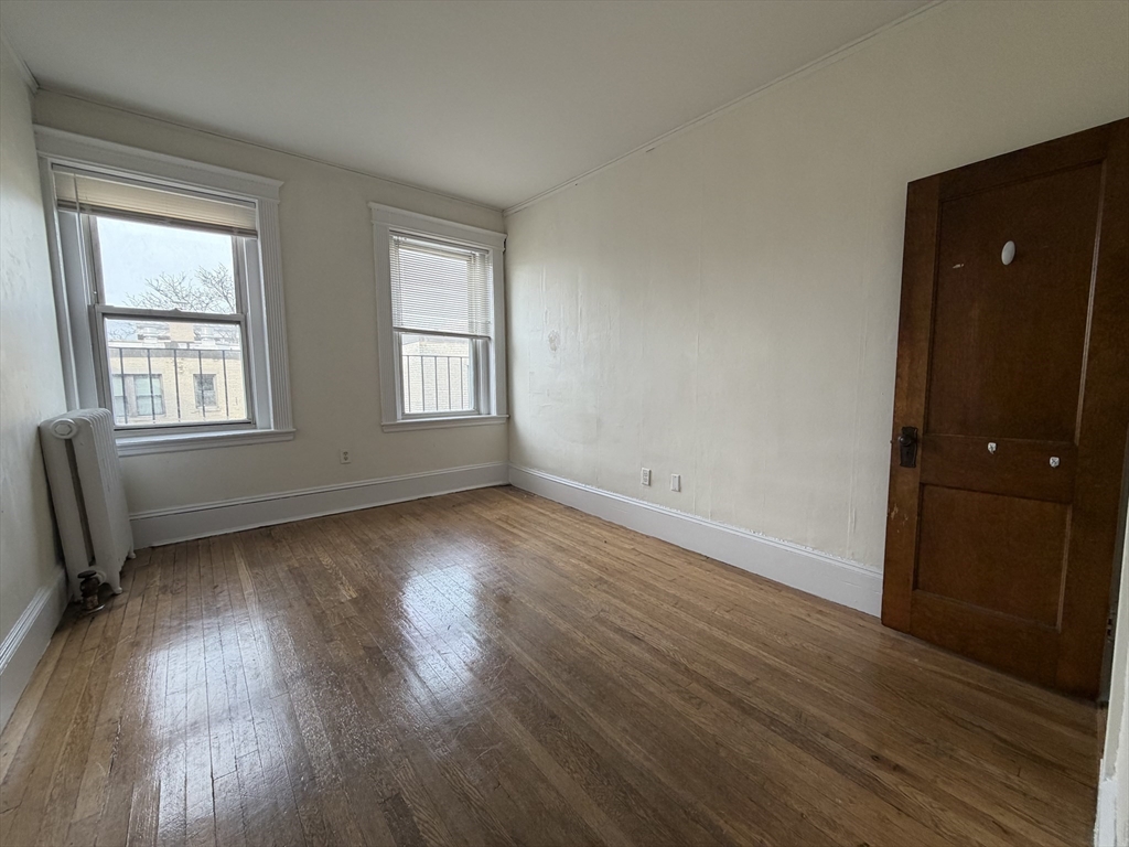 331 Huntington Avenue, Unit 45 Boston, MA 02115 - Photo 3 of 5 an empty room with wooden floor and windows
