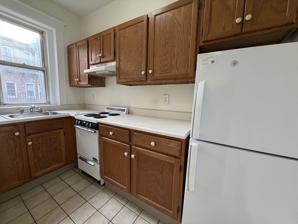 331 Huntington Avenue, Unit 45 Boston, MA 02115 - Photo 4 of 5 a kitchen with stainless steel appliances granite countertop a refrigerator stove a sink and dishwasher