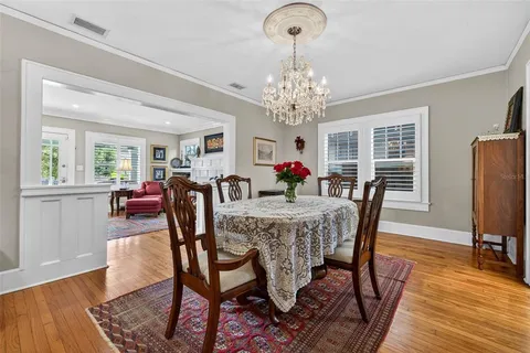 a view of a dining room with furniture a chandelier and wooden floor