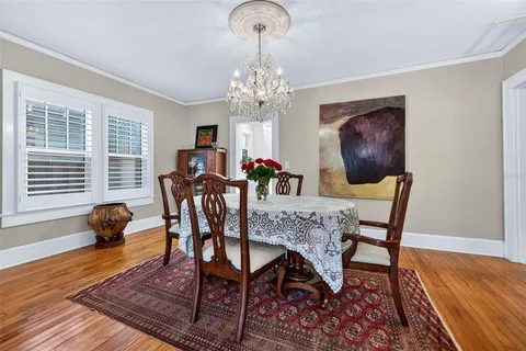 a dining room with furniture a chandelier and wooden floor