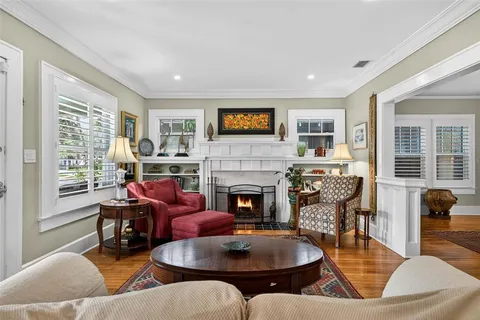 a living room with fireplace furniture and a large window