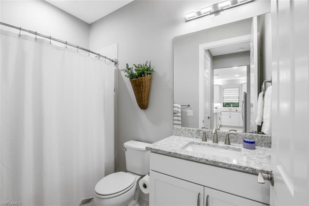 7682 Jacaranda Lane Naples, FL 34114 - Photo 11 of 30 a bathroom with a granite countertop sink and a mirror