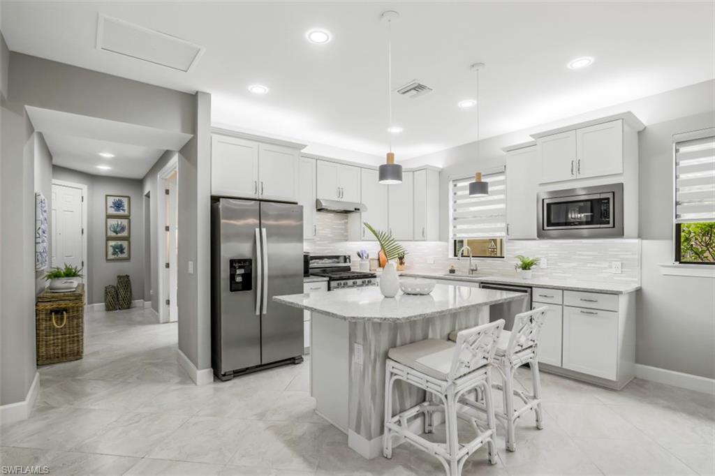 7682 Jacaranda Lane Naples, FL 34114 - Photo 2 of 30 a kitchen with stainless steel appliances a sink stove and refrigerator