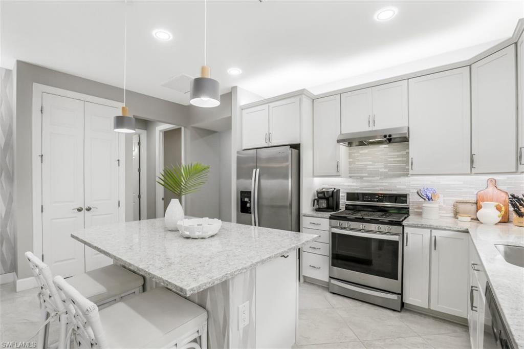 7682 Jacaranda Lane Naples, FL 34114 - Photo 3 of 30 a kitchen with stainless steel appliances a stove a sink a refrigerator and cabinets