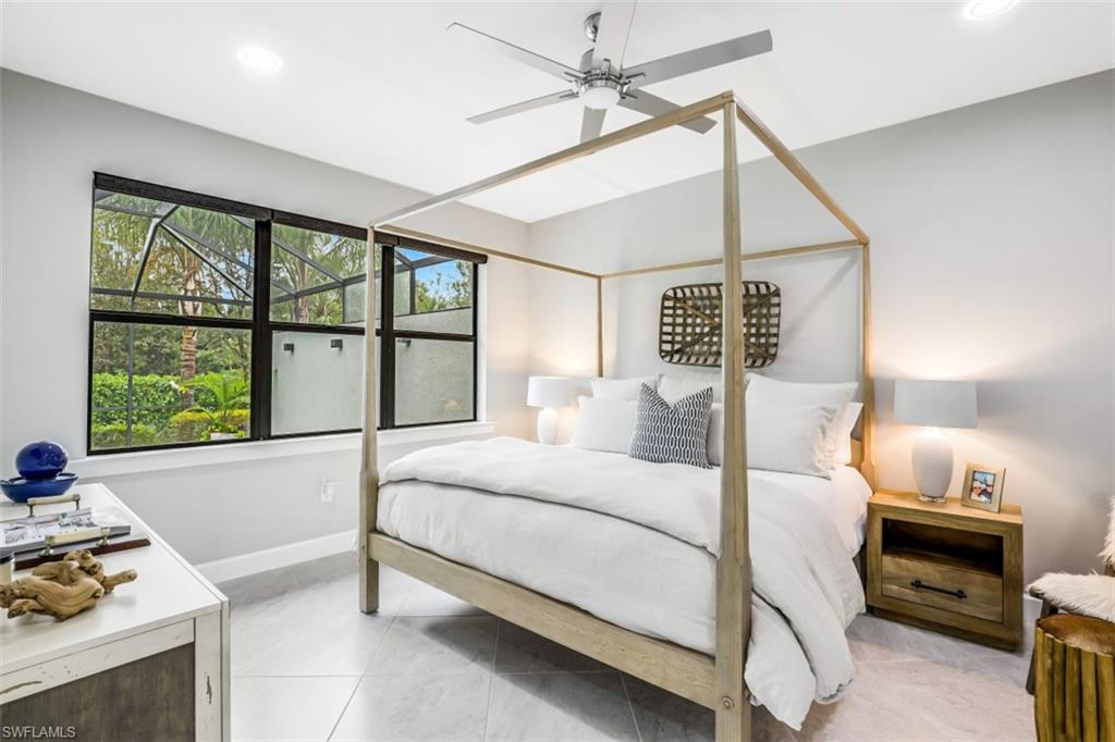7682 Jacaranda Lane Naples, FL 34114 - Photo 8 of 30 a bedroom with a bed next to a window with a chandelier